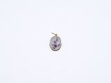 a close up of a small pendant with a flower design on it