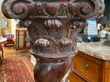 a large wooden column with carvings on it in the middle of a room