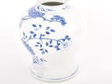 a white vase with blue flowers on it on a white surface