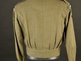 a green jacket on a mannequin stand with a black background