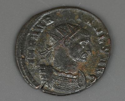 une vieille pièce de monnaie sur laquelle est représentée une couronne, posée sur une table