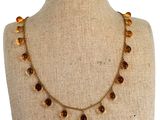 collier composé de perles de verre, présenté sur un mannequin muni d'une chaîne en or