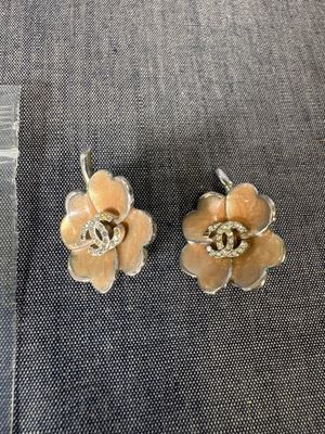 une paire de boucles d'oreilles en forme de fleurs jaunes posées sur un tissu bleu