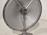a small metal object on a table with a white wall in the background