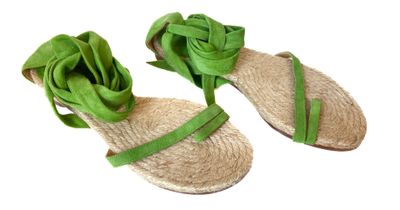 pair of women ' s sandals with a green ribbon on them