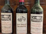 trois bouteilles de vin sont alignées sur une table rouge