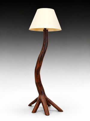 un lampadaire en bois surmonté d'un abat-jour blanc
