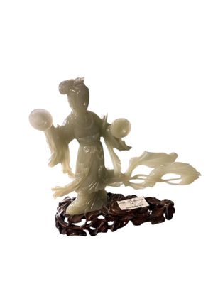statue of a woman holding a flower and a ball on a stand