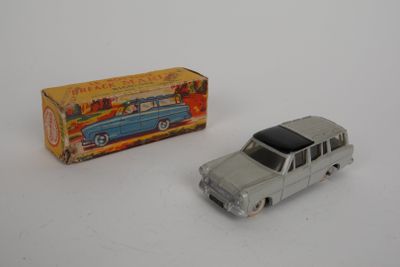 une petite voiture et une boîte posées sur une surface blanche