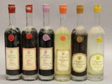 six bouteilles d'alcool sont alignées sur une surface blanche
