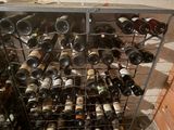 many bottles of wine in a metal rack on the floor
