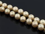 un gros plan sur un collier de perles sur une surface noire
