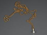 a gold necklace with a diamond on a chain
