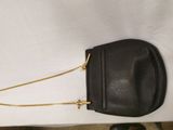 a black purse with a gold chain hanging from it ' s side