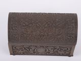 an old wooden box with carvings on it sitting on a white surface