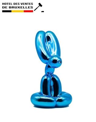the blue rabbit statue is sitting on top of a white surface