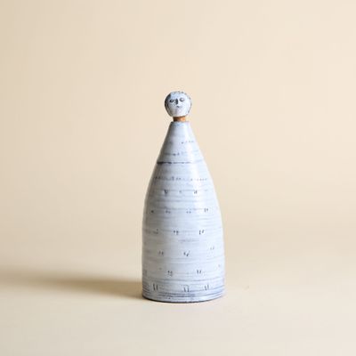 un vase blanc surmonté d'une boule