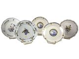 six assiettes ornées de motifs bleus et blancs sont alignées sur une surface blanche