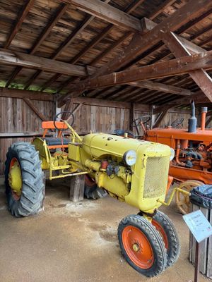 un tracteur garé dans une grange avec d'autres tracteurs