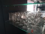 de nombreux verres à vin posés sur une étagère en verre dans un magasin