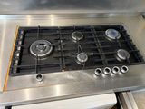 a stainless steel stove top with four burners on it