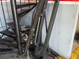 a pile of metal stairs in a garage next to a wall