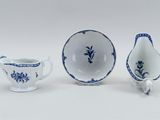 three pieces of blue and white porcelain on a white surface