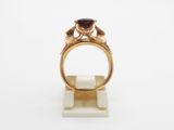 a close up of a gold ring with a garnetite stone on it