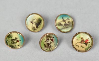 quatre petits boutons ornés d'images d'animaux, posés sur une table