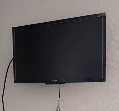 une télévision à écran plat fixée au mur au-dessus d'un bureau