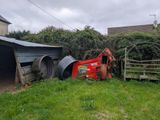 a tractor that is parked next to a shed