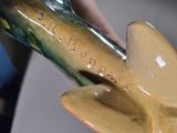 a close up of a vase with a bird on it