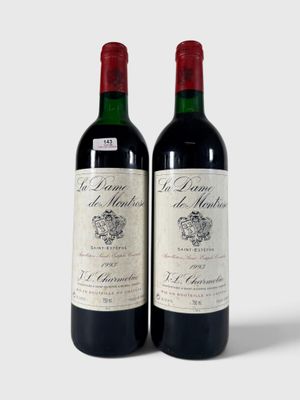 deux bouteilles de vin rouge posées l'une à côté de l'autre sur une surface blanche