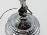 a silver lamp that is on a white table