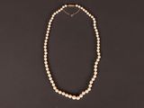 un collier de perles blanches sur fond noir