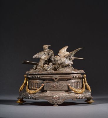 une sculpture antique en bronze représentant des oiseaux, posée sur un socle