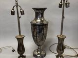 trois vases en argent posés l'un à côté de l'autre sur une table