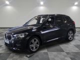 the bmw x1 is parked in a large room with a checkered floor