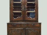 une vieille armoire en bois avec une porte vitrée et deux étagères