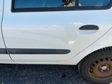 un homme assis dans une petite voiture blanche