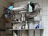 de nombreuses casseroles et poêles accrochées au mur de la cuisine