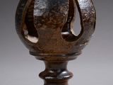 a close up of a vase on a stand on a gray surface