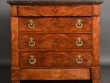 an antique chest of drawers with a marble top