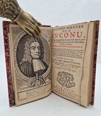 an open book with a hand holding a book with a picture of a man ' s hand on top of it