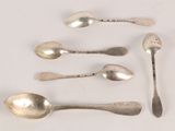several spoons and spoon spoons are lined up on a white surface