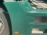 a green semi truck that is parked on the side of the road