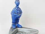 une figurine bleue représentant un homme sur une planche de surf