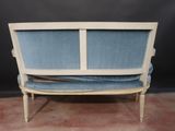 an image of a blue and white couch sitting on top of a carpeted floor
