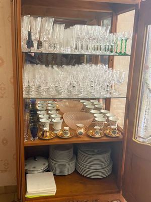 a wooden cabinet with many plates and glasses on it