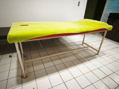 une planche de surf jaune posée sur un support métallique dans une pièce